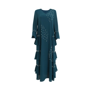 Detailed close-up of beaded white pearls and layered ruffles on dark cyan chiffon gown