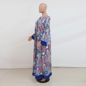 Détail d'une robe longue bohème avec des motifs géométriques et des finitions à franges bleues