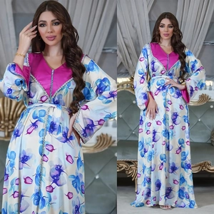 Detail of satin kaftan dress featuring orchid prints and beaded V-neckline embroidery