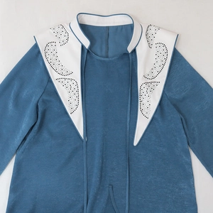Close-up of blue long sleeve dress with rhinestone-embellished pointed collar and tie