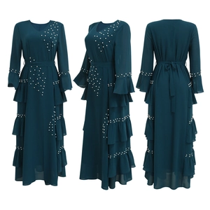 Detail of beaded pearls and layered ruffle hem on teal chiffon maxi dress with bell sleeves