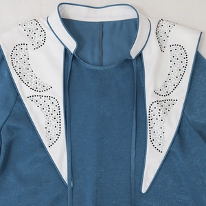 Close-up of contrast jalabiya neckline with rhinestones and decorative tie-up detail