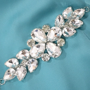Nahaufnahme der silbernen Diamantkette mit Strasssteinen auf blauem Seidenhintergrund