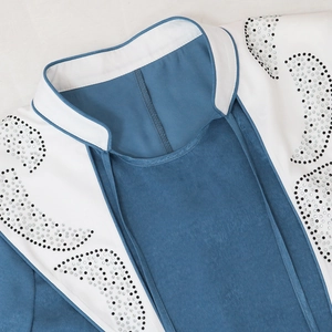 Detail of jalabiya collar with silver and black rhinestones on blue and white fabric