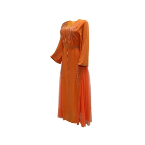 Detail of orange mesh kaftan dress featuring gold embroidery and sequin embellishments