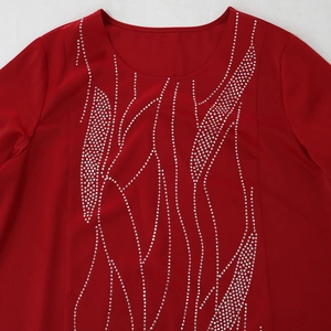 Detail of red long dress with abstract silver rhinestone pattern on the chest