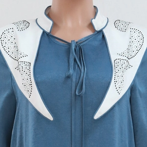 Detail of blue jalabiya dress featuring white contrast collar with sparkly rhinestones