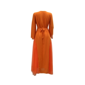 Detail of orange kaftan dress showing sheer mesh side panels and back tie waist details