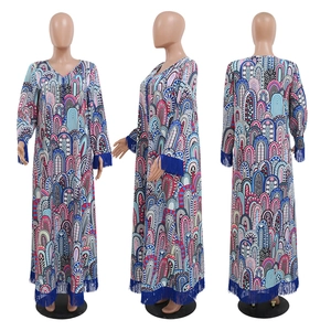 Détail de franges à glands bleus sur une robe longue caftan à imprimé géométrique
