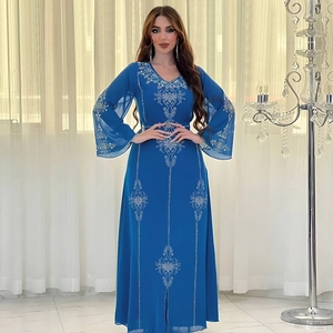 Détail d'une robe de soirée en mousseline bleu roi avec strass blancs et manches fendues évasées