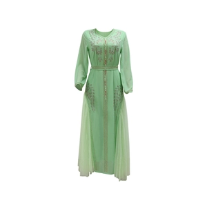 Detailed view of hand-sewn golden beads and floral rhinestones on light green mesh dress