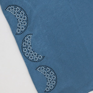 Detail view of rhinestones in crescent shapes on high-quality blue Jalabiya dress fabric