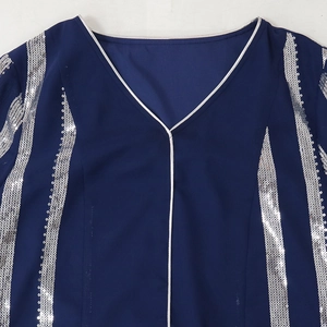 Detail of V-neckline with silver sequins and striped patterns on navy blue chiffon fabric