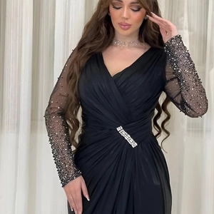 Detail of evening gown featuring mesh long sleeves with hand-stitched beads and rhinestones