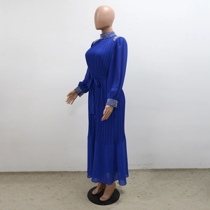 Détail de strass argentés sur l'encolure et l'épaule d'une robe longue plissée bleu roi