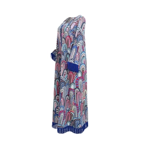 Détail d'une robe caftan imprimée à manches longues avec des franges bleues aux poignets