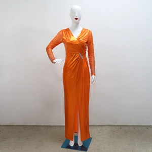 Detailed view of bright orange metallic evening gown with waist pleats and diamond buckle