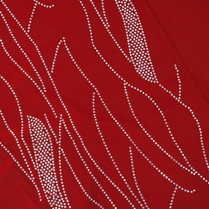 Detail of silver rhinestones in leaf patterns on elegant red fabric long dress