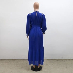 Détail d'une robe plissée bleu roi avec ornements en strass argentés sur les épaules