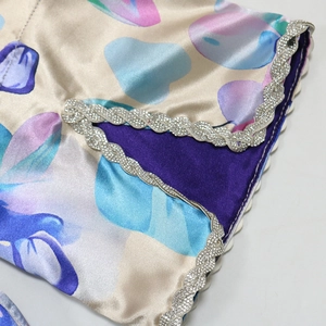 Detailed macro view of satin robe sleeve with diamond trim and heart print pattern