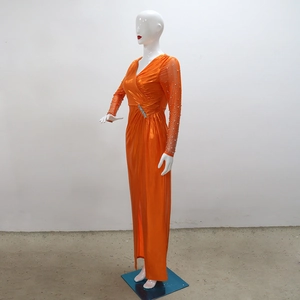 Detail of orange evening gown featuring crystal beaded sleeves and deep V-neckline