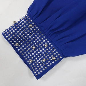 Détail de la manche d'une robe bleu roi avec ornements complexes en strass et perles argent
