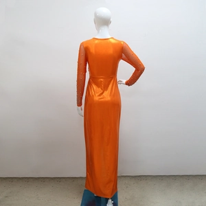 Detail of orange evening gown featuring rhinestone sleeves and metallic fabric texture