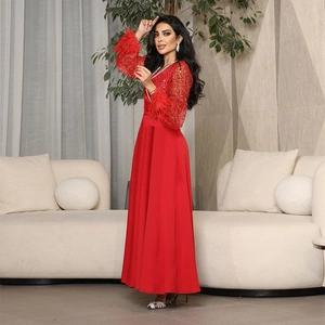 Elegante abito da sera rosso con corpino di paillettes e polsini di piume a linea A