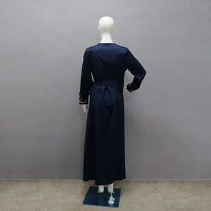 Dettaglio dell'elegante abito da sera in raso blu navy con ricami sui polsini della manica