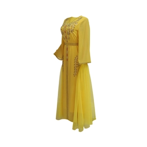 Detail of yellow kaftan dress with intricate gold and red sequin embroidery patterns