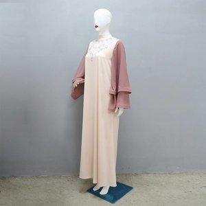 Dettaglio dello scollo con strass e maniche a campana su un abito abaya in raso