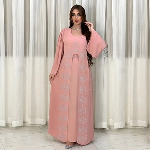 Détail de la broderie et des strass sur une robe abaya rose en mousseline à manches longues
