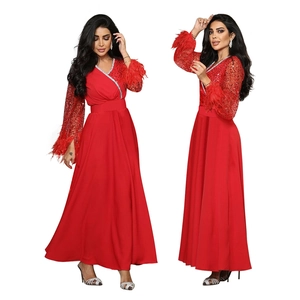 Elegante abito da sera rosso con maniche di paillettes e bordi in piume ai polsini