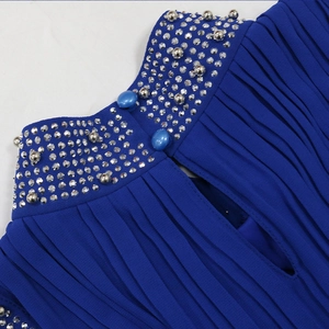 Détail de l'encolure plissée bleu marine avec strass brillants et décorations de perles