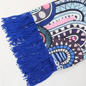Détail d'un caftan bleu royal avec imprimé bohème et longues franges à glands
