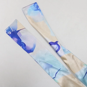 Detail of silk-like Twilly scarves with blue and purple abstract floral print