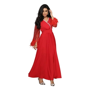 Elegante abito lungo rosso con maniche di paillettes, polsini di piume e scollo a V