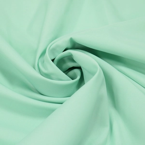 Gros plan du tissu en mousseline vert menthe avec texture douce et drapé élégant
