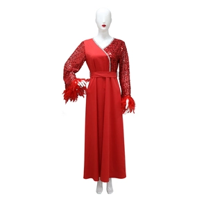 Dettaglio dell'abito rosso con paillettes, polsini in piume e scollatura a V scintillante
