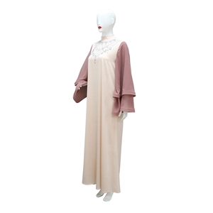 Dettaglio dello scollo con strass e maniche a campana sull'abito abaya in raso