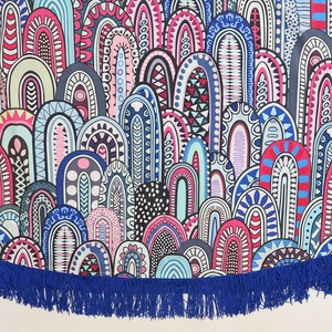 Vue détaillée du tissu à motifs bohèmes avec des pompons à franges bleus vifs
