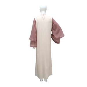 Dettaglio delle maniche a campana multistrato su un abito abaya in raso con strass