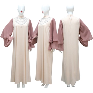 Dettaglio dello scollo con strass e maniche a campana sulla veste abaya in raso bicolore