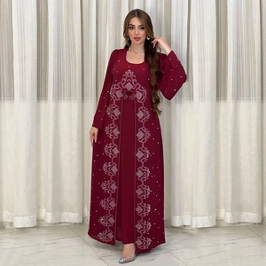 Gros plan de la robe en mousseline bordeaux avec motifs ethniques en strass argentés