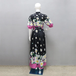 Rear view of long daisy floral dress with pink hem and matching printed waist belt