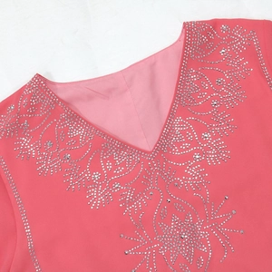 Détail du col en V avec strass argentés sur cette robe de soirée en mousseline rose