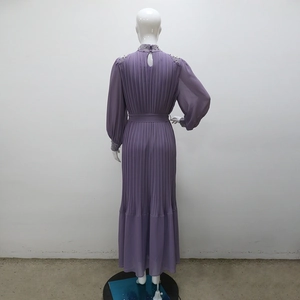 Détails du dos de la robe plissée mauve avec col et poignets ornés de strass brillants