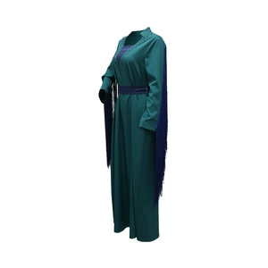 Close-up of deep green abaya featuring long blue tassels and rhinestone details