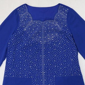 Détail de la robe en mousseline bleu marine avec strass étincelants sur l'encolure carrée