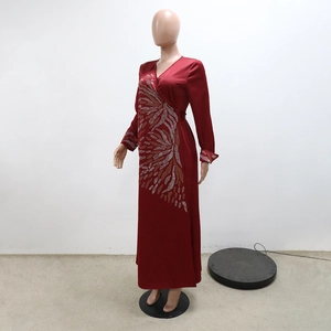 Dettaglio dell'abito lungo in raso bordeaux con motivo a foglie di strass e scollo a V